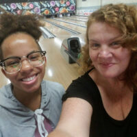 Mother and daughter enjoying bowling alley