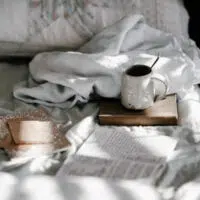 cup and book on bed