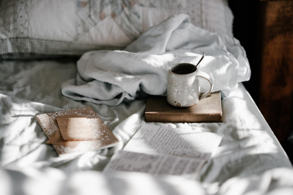 cup and book on bed