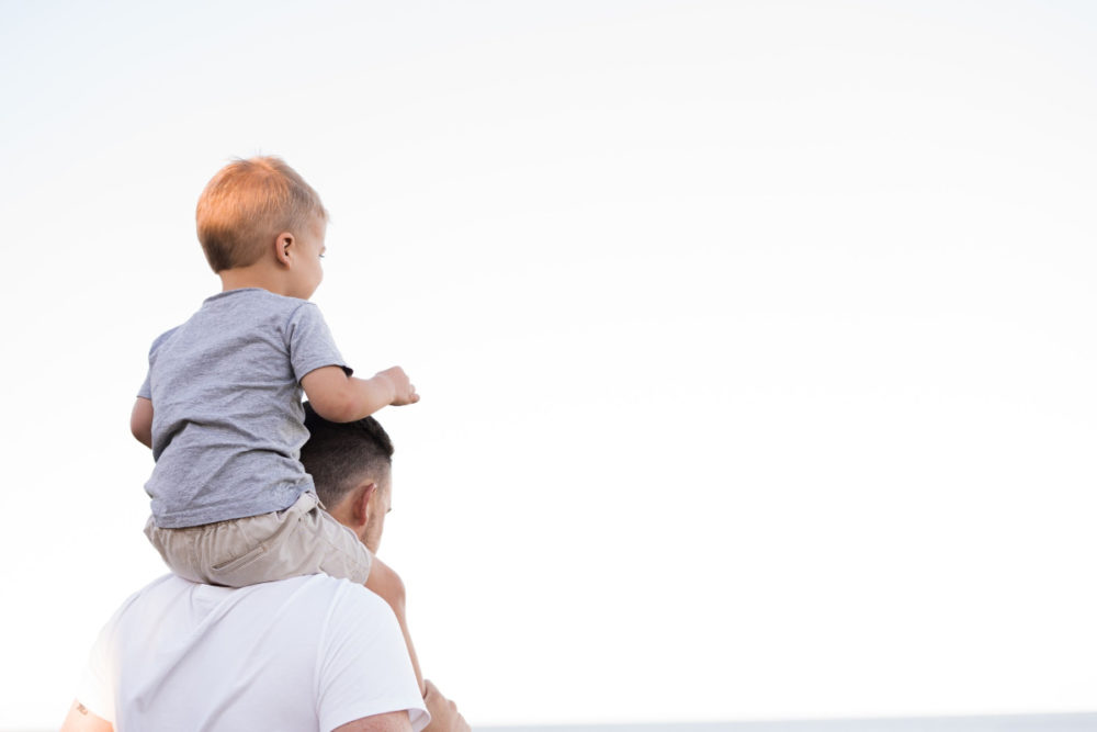 man with child on shoulders