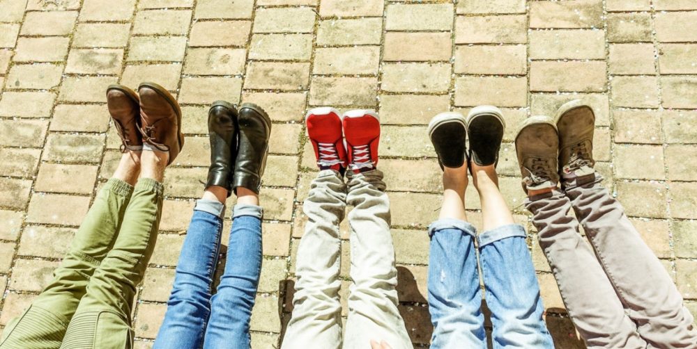 peoples legs and shoes sitting on floor