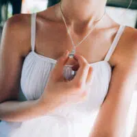 woman holding pendent.