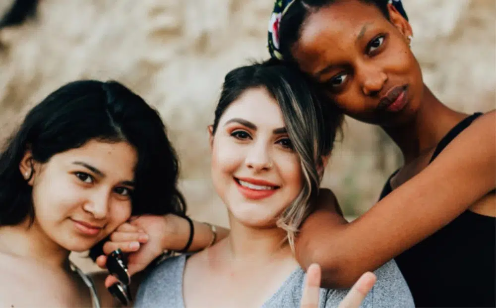 three women leaning on each other