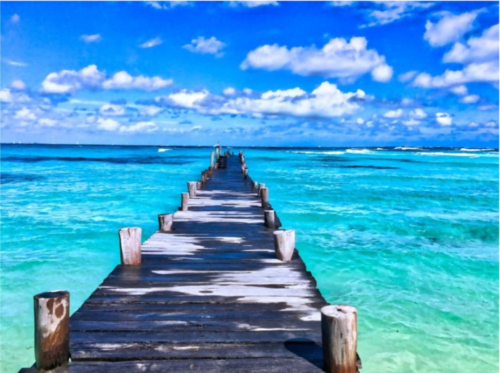 pier over blue green water 