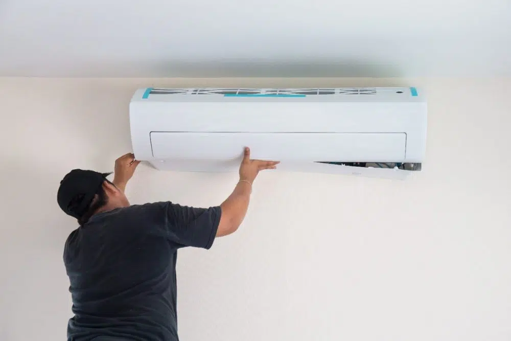 man putting up AC unit