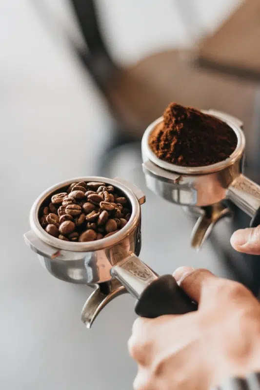 erson holding gray coffee racks