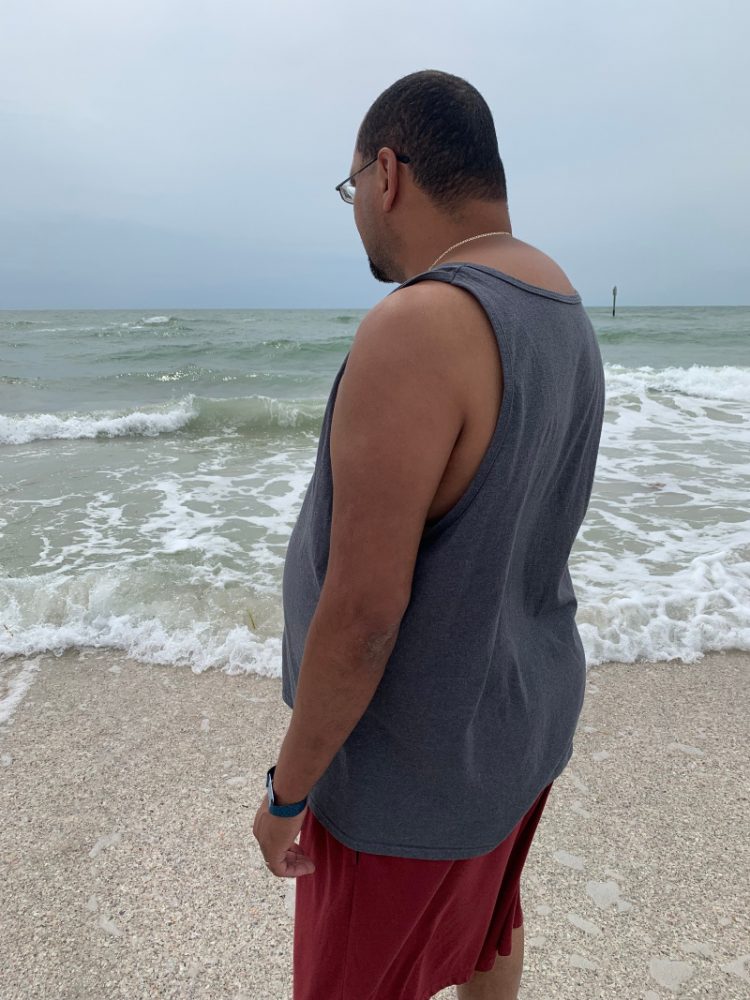 man on beach watching water