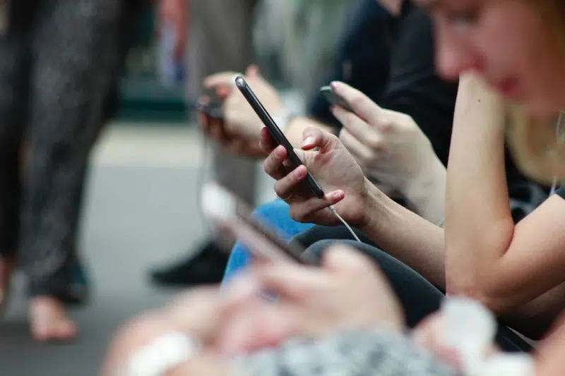 people sitting with phones in hands