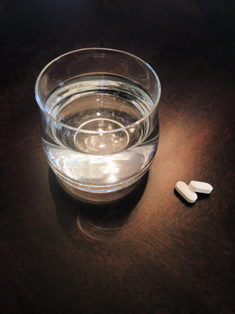 glass of water and pills on table 