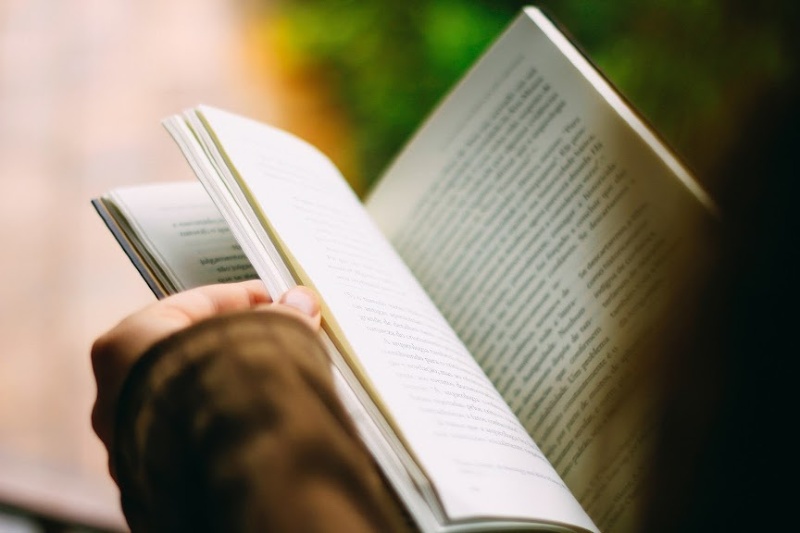 person turning a books page