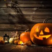 Halloween pumpkin head jack lantern on wooden background