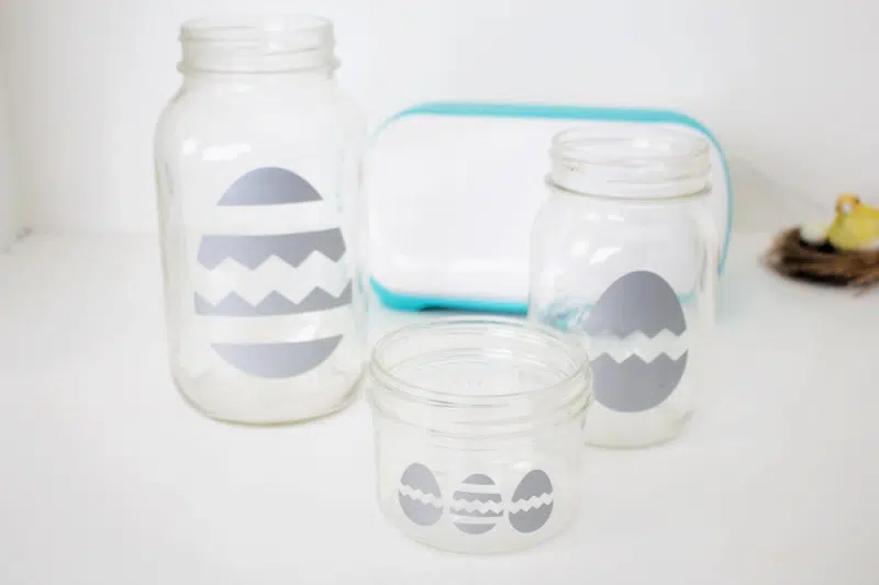 three glass jars with eggs on them 