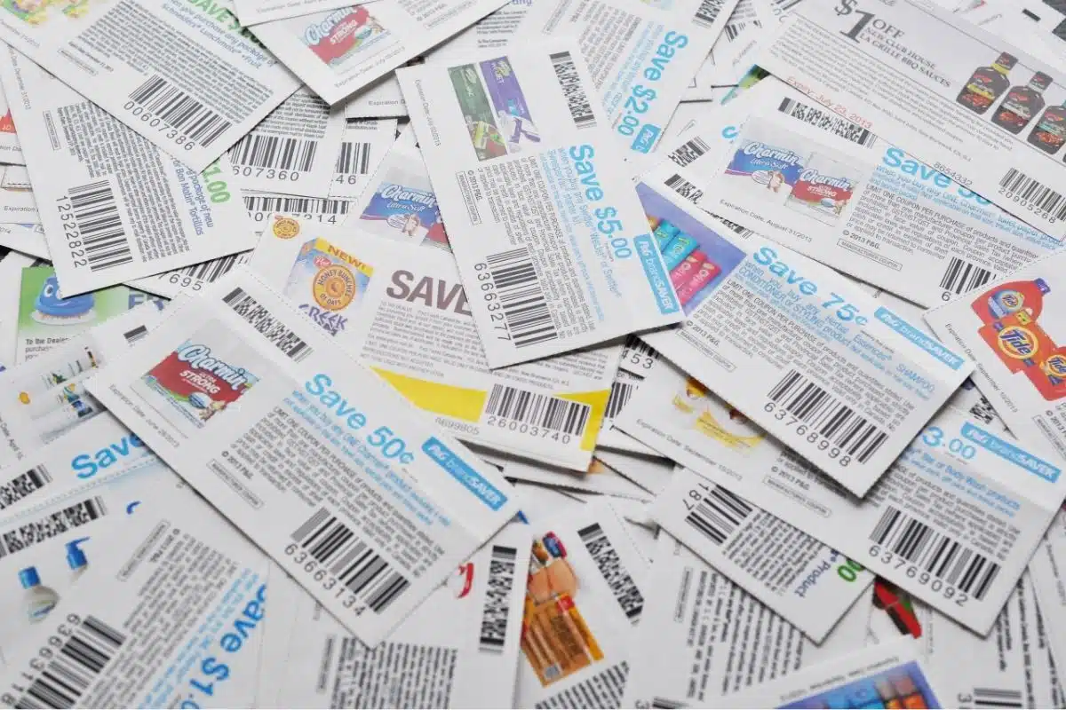A pile of various coupons with barcodes, revealing the best dollar store secrets for discounts on different products, enhancing your shopping experience.