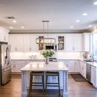 Spacious and elegant kitchen featuring white cabinetry, island, and stainless steel appliances.