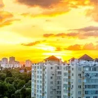 Stunning sunset over Chișinău cityscape with modern high-rise buildings.