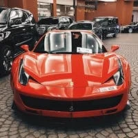 Red Ferrari sports car showcased at Dubai Mall, UAE, symbolizing luxury and elegance.