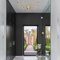Stylish corridor with marble flooring, chandelier, and outdoor view.