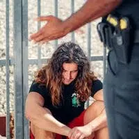 A police interaction with a seated man outside showing a tense moment.