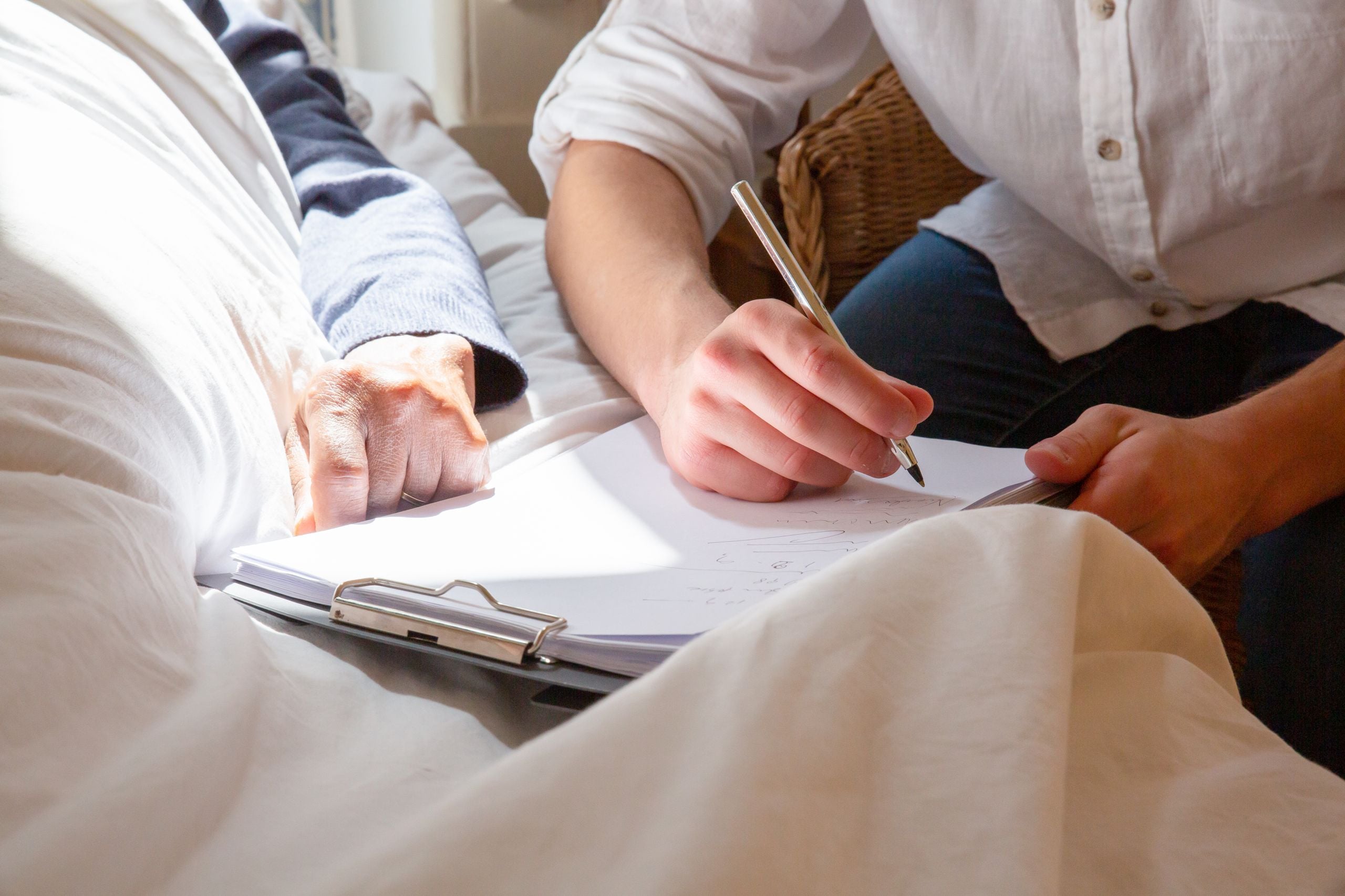 A caregiver's supportive interaction with a senior in a sunlit room, highlighting care and connection.