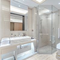 A stylish bathroom featuring a glass shower, marble sink, and elegant decor.