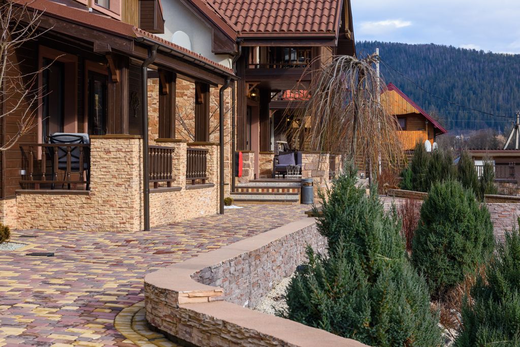 Beautiful rustic house exterior with landscaped walkway in a tranquil countryside setting.