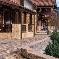 Beautiful rustic house exterior with landscaped walkway in a tranquil countryside setting.