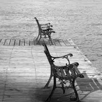 Black and white photo of empty benches on a lakeside pier in Guntersville, Alabama.