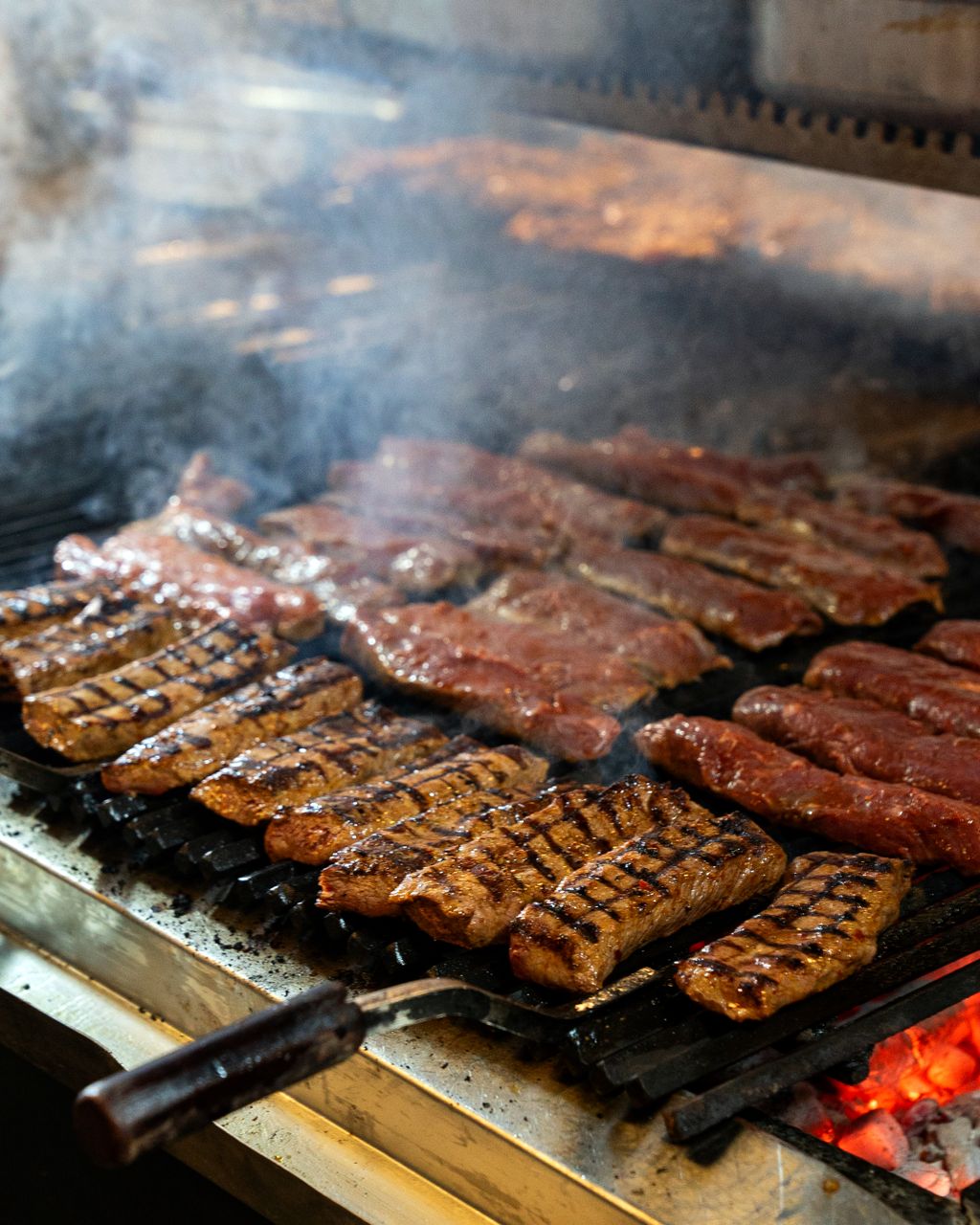 Juicy cuts of meat being grilled with smoky flavors on a barbecue grill.