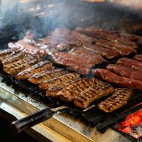 Juicy cuts of meat being grilled with smoky flavors on a barbecue grill.