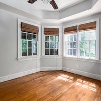 Spacious room with bay windows and wooden floor, perfect for home design inspiration.